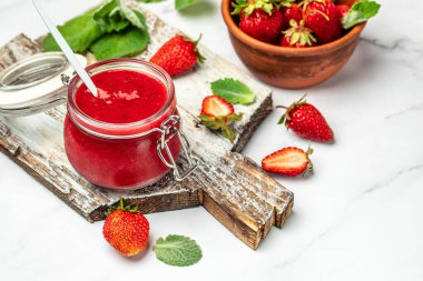 Kavanozda çilek reçeli ve tahtada taze böğürtlen. afiş, menü, metin için tarif yeri.