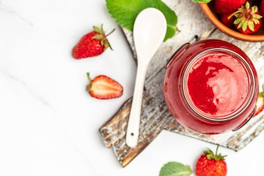 Beyaz arka planda bir kavanoz çilek reçeli. Ev yapımı çilekli marmelat ve meyve. Uzun pankart biçimi.