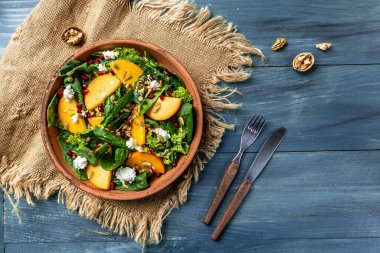 Hurma, avokado, kabak tohumu, ceviz, nar ve roka aromalı gurme salatası. Pankart. Üst görünüm.