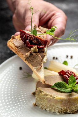Lezzetli tavuk ciğeri ezmesi, tereyağı, kurutulmuş domates ve tabakta ekmek. Sağlıklı gıda eğilimi.
