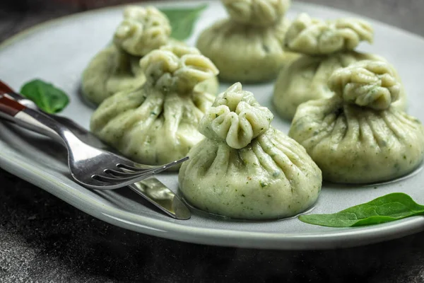 Hot Khinkali with cheese and spinach. Restaurant menu, dieting, cookbook recipe top view.
