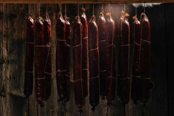 stock image Process of smoking sausage hang in a cupboard with smoke. Clouds of smoke rise up and envelop the sausages hanging in a row.