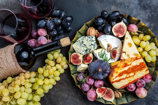 Appetizers table with italian antipasti snacks and wine in glasses. cheese, ham, nuts, fruit, bread sticks. Delicious balanced food concept, Long banner format. top view,