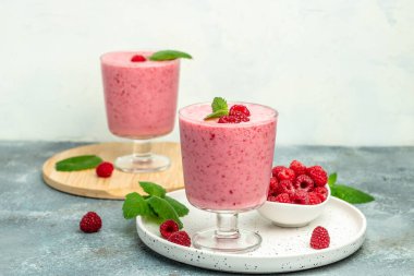 Ahududulu smoothie milkshake ya da böğürtlenli cam kavanozda yoğurt. Mavi arka planda yoğurt kokteyli. metin için yer, üst görünüm.