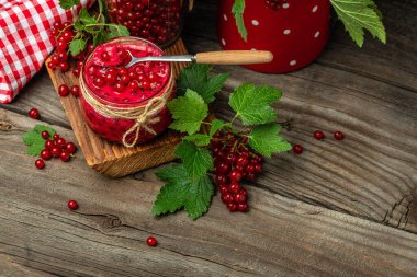 Kavanozda frenk üzümü reçeli. Ahşap arka planda taze meyve konservesi. afiş, menü, metin için tarif yeri.