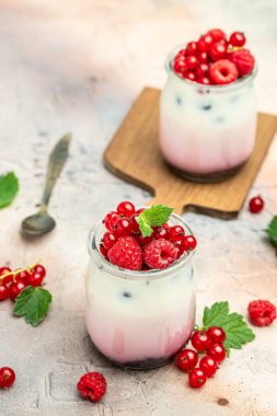 Raspberry dessert cheesecake, trifle, mouse in a glass. Raspberry Greek yogurt granola parfait on a light background. Restaurant menu, dieting, cookbook recipe.