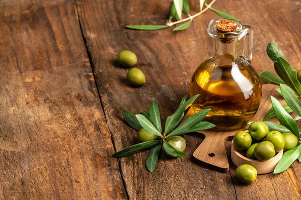 green olives with olive oil. extra virgin olive oil jars on a wooden background. place for text.