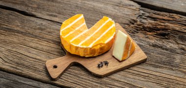 Krem rengi brie peyniri ya da ahşap bir tahtanın üzerindeki camambert peyniri. Ahşap zemin, pankart, menü, metin için tarif yeri, üst görünüm üzerinde güzergah peyniri.