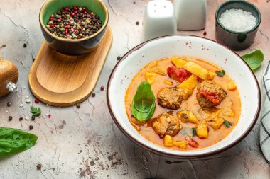 Etli, patatesli, soğanlı güveç, domates soslu kabak, sarımsak ve otlar beyaz bir kasede, yazı için yer, üst görünüm,