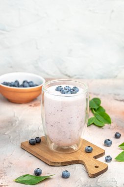 Blueberry jogurt, Tasty blueberry smoothie in glass on a light background, vertical image. place for text,