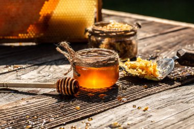 Eski köy masasında kaşığı olan doğal bal. Arı ürünleri organik doğal bileşenler konsepti, yakın çekim.