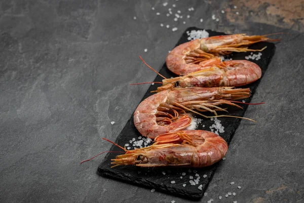 Seafood. Red Argentine shrimps with salt and lemon, Wild shrimps, ocean jumbo shrimps on a dark background. banner, menu, recipe place for text, top view.