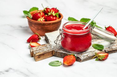 Beyaz arka planda bir kavanoz çilek reçeli. Ev yapımı çilekli marmelat ve meyve. Uzun pankart biçimi.