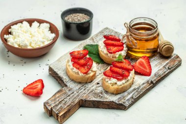 Crostini veya çilekli tost ve krem peynirli ricotta. Lezzetli kahvaltı ya da atıştırmalık, temiz yemek, diyet, vejetaryen yemek konsepti. en üstteki görünüm.