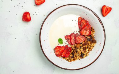 Yoğurtla yoğurt, taze çilek, chia tohumu ve gri arka planda bal. Lezzetli dengeli gıda konsepti. afiş, menü, metin için tarif yeri, üst görünüm.