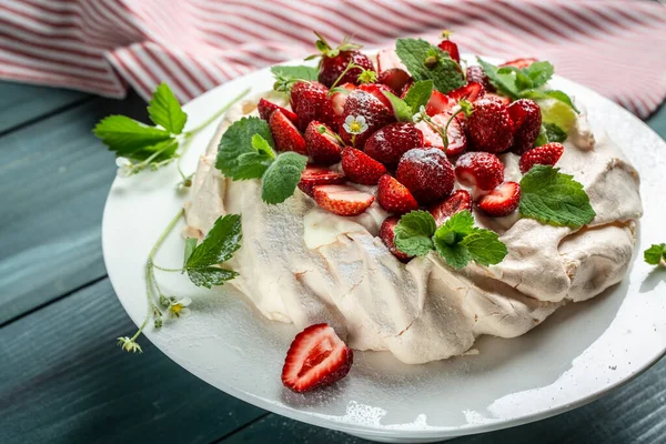 Homemade delicious meringue cake Pavlova with whipped cream, fresh strawberries,