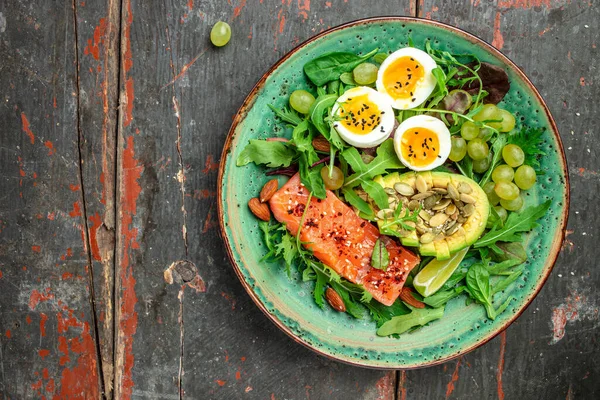 salmon salad with greens, eggs and avocado. Delicious breakfast or snack, Healthy keto lunch or dinner. top view copy space.