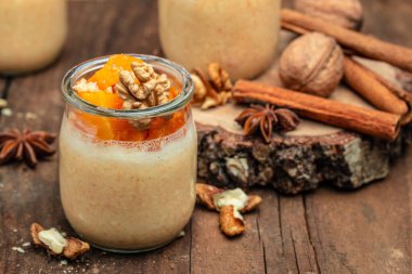 Bardakta fındıklı kabak parfe. Ahşap arka planda balkabağı parfe. Lezzetli dengeli gıda konsepti. metin için yer.