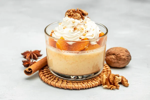 stock image dessert with pumpkin, whipped cream. Pumpkin parfait with nuts in glass on a light background. banner, menu, recipe place for text, top view.