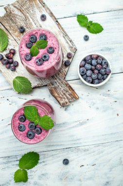 Hafif arkaplanda Bilberry yoğurt kokteyli. Doğal detoks. dikey görüntü. Üst Manzara. metin için yer.