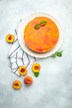 Şeftalili jöleli cheesecake. Restoran menüsü, diyet, yemek kitabı tarifi. dikey görüntü. Üst Manzara. metin için yer.