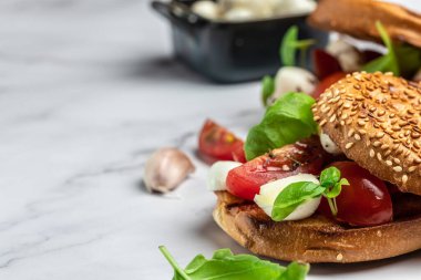 Mozzarella, kiraz domatesli ve taze fesleğenli Caprese tostları. Geleneksel İtalyan aperatifi veya aperatifi, antipasto. afiş, menü, metin için tarif yeri, üst görünüm.