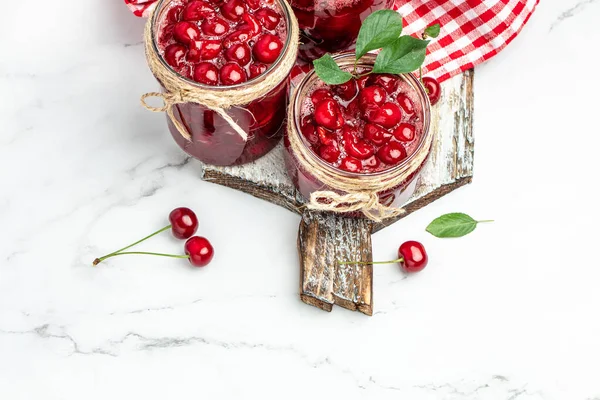 Jar of cherry jam and sour cherries. Berries cherry with syrup. Ripe ripe cherries. Sweet red cherries. Canned fruit. place for text, top view,