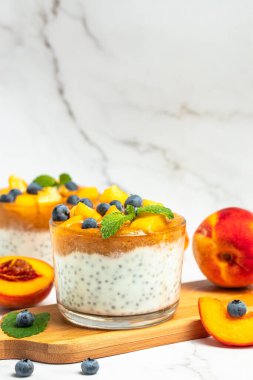 Healthy chia pudding with yogurt and fruit Peach and blueberry. Homemade dessert with fruits. place for text, top view.