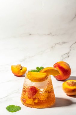 homemade peach sangria with ice cubes, and mint, Refreshing summer homemade cocktails, on a light background, vertical image. top view. place for text,