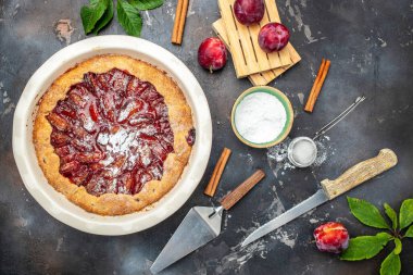 Homemade plum pie. A woman cuts a plum cake with a knife, Food recipe background. Close up,