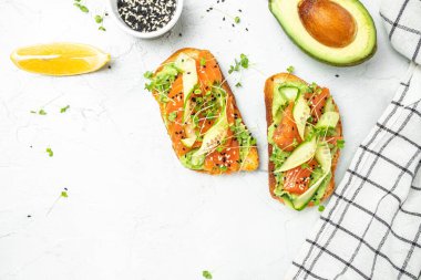 Tuzlu somon, avokado ve taze sebzeli sandviç. Lezzetli kahvaltı ya da atıştırmalık, temiz yemek, diyet, vejetaryen yemek konsepti. en üstteki görünüm