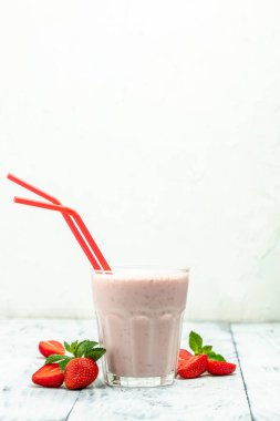Meyveli smoothie. Çilekli smoothie ya da meyveli milkshake ve beyaz arka planda cam kavanozda yoğurt. Sağlıklı vejetaryen içeceği.