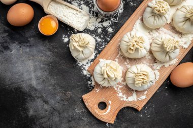 Khinkali. Cutting board with raw khinkali with meat, semi-finished products dumplings. cooking khinkali. National Georgian cuisine.