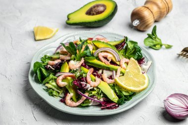 Taze avokado salatası, karides, marul yeşili karışım ve zeytinyağı, limon sosu. Sağlıklı yemek, lezzetli kahvaltı ya da atıştırmalık, temiz yemek, diyet, vejetaryen yemek konsepti. en üstteki görünüm.