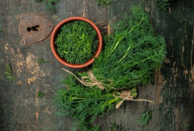 Bahçeden bir demet taze dereotu eski ahşap masada, bir kase içinde dereotu, kırsal tarzda. Üst Manzara. metin için yer,