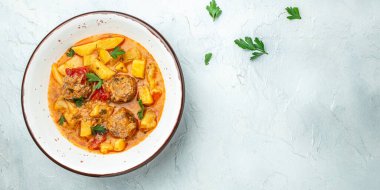 Hafif arka planda köfteli güveç, lezzetli dengeli gıda konsepti, uzun afiş formatı. en üstteki görünüm.