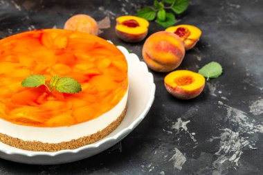 Şeftalili cheesecake, şeftali reçeli, koyu arkaplanda reçel. afiş, menü, metin için tarif yeri, üst görünüm.