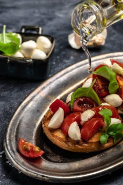 Mozzarella, kiraz domatesli ve taze fesleğenli Caprese tostları. Geleneksel İtalyan aperatifi veya aperatifi, antipasto. en üstteki görünüm.