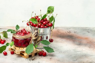 Kavanozda kiraz reçeli ve masada taze böğürtlen. Arka planda bahçeden gelen organik gıdalar korunmuş. afiş, menü, metin için tarif yeri.