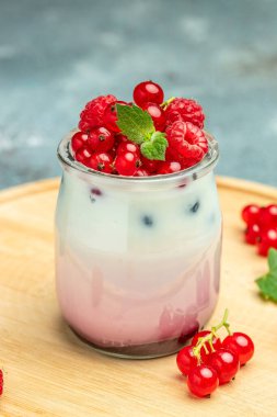 Ahududulu yoğurt. Sağlıklı kahvaltıda Yunan yoğurdu, ahududu ve nane şekeri. Meyveli buzlu içecek. sağlıklı beslenme konsepti.