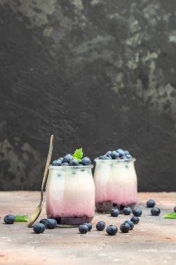 Tatlı yaban mersini ve jöle kavanozlarda hafif arkaplanda. Lezzetli dengeli gıda konsepti. metin için yer, üst görünüm.