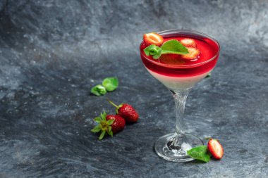 Geleneksel İtalyan tatlı panna cotta koyu arkaplanda çilekli jöle. Yazlık yoğurt tatlısı. Uzun afiş biçimi. Metin için boşluk,