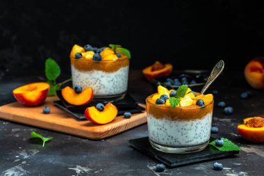 homemade dessert with fruits, parfait yogurt with peaches blueberry and chia. place for text.