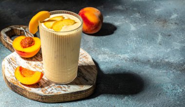 Şeftali suyu. Şeftalili süt ve protein karışımı, yaz kahvaltısı içeceği. metin için yer, üst görünüm.