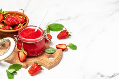 Beyaz arka planda bir kavanoz çilek reçeli. Ev yapımı çilekli marmelat ve meyve. Uzun pankart biçimi.