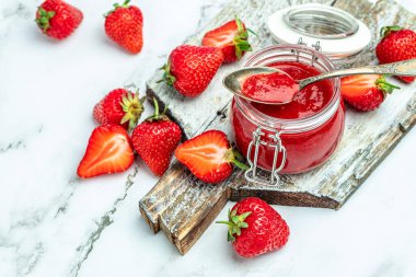 Beyaz arka planda bir kavanoz çilek reçeli. Ev yapımı çilekli marmelat ve meyve. Uzun pankart biçimi.