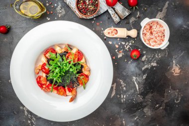 Karides ve kiraz domatesli siyah makarna. Lezzetli dengeli gıda konsepti, afiş, menü, metin için tarif yeri, üst görünüm,