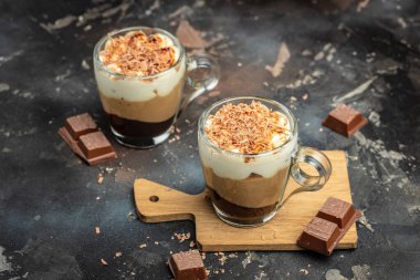 Tahta bir tahtanın üzerinde cam bir kavanozda üç çikolata. Yemek tarifi geçmişi. Kapat..