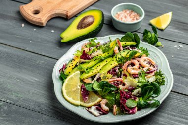 Taze avokado salatası, karides, marul yeşili karışım ve zeytinyağı, limon sosu. Sağlıklı yemek, lezzetli kahvaltı ya da atıştırmalık, temiz yemek, diyet, vejetaryen yemek konsepti. en üstteki görünüm.