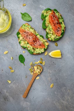 Avokadoo, somon ve ıspanak, fındık ve ayçekirdeği ile tost. Sağlıklı, temiz yemek. Vejetaryen ya da glütensiz diyet. Üst görünüm, boşluk kopyala.
